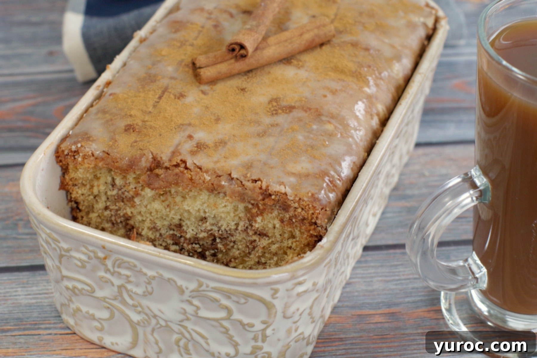 cinnamon loaf with sliced removed beside a cup of coffee