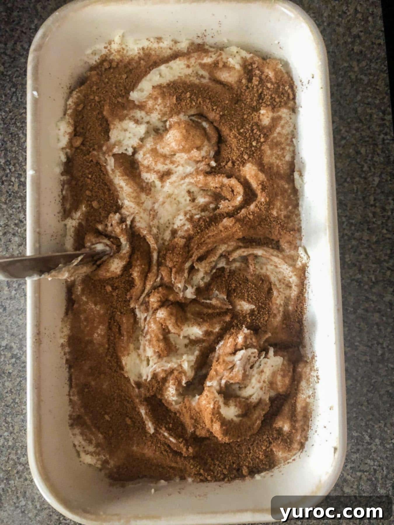 cinnamon brown sugar being mixed in with batter with a knife
