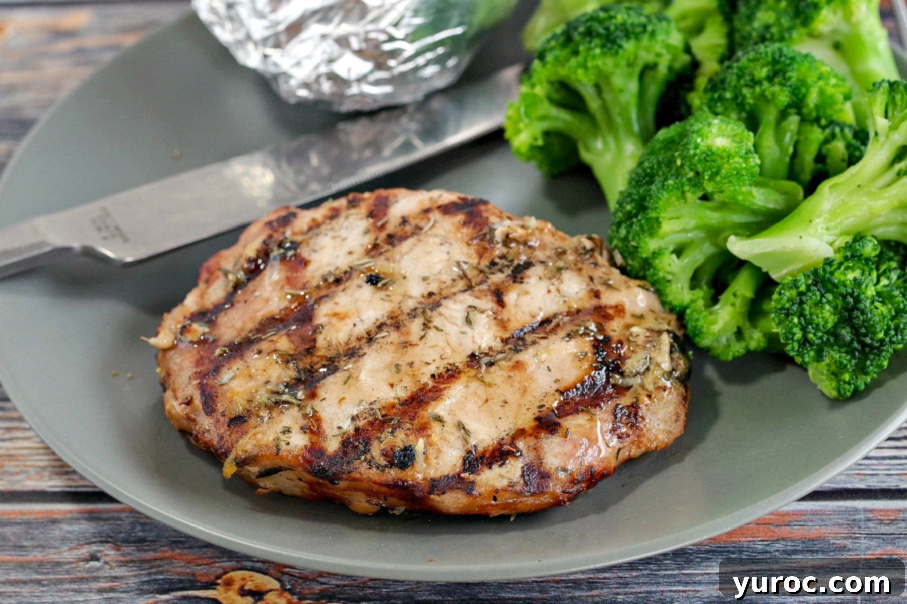 Maple lemon pork on a plate with broccoli and baked potato in foil