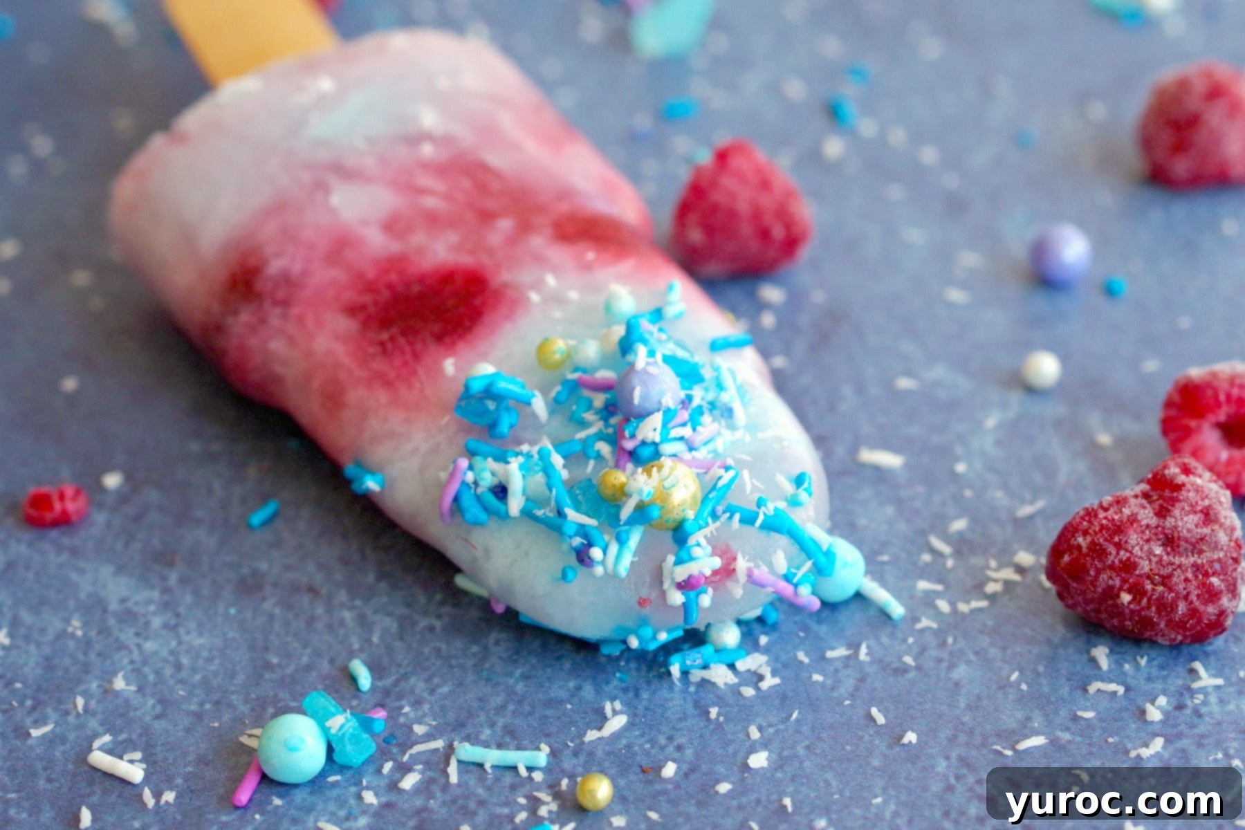 A single festive red, white, and blue popsicle resting on a blue surface, adorned with sprinkles, perfect for celebrations.
