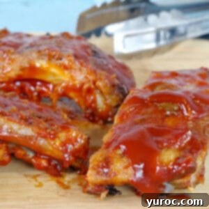 slow cooker ribs with beer on a cutting board with thongs in the background