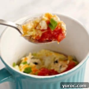 A fluffy, golden-brown microwave mug omelette held elegantly on a spoon, hovering over a vibrant blue mug, ready for a healthy breakfast.