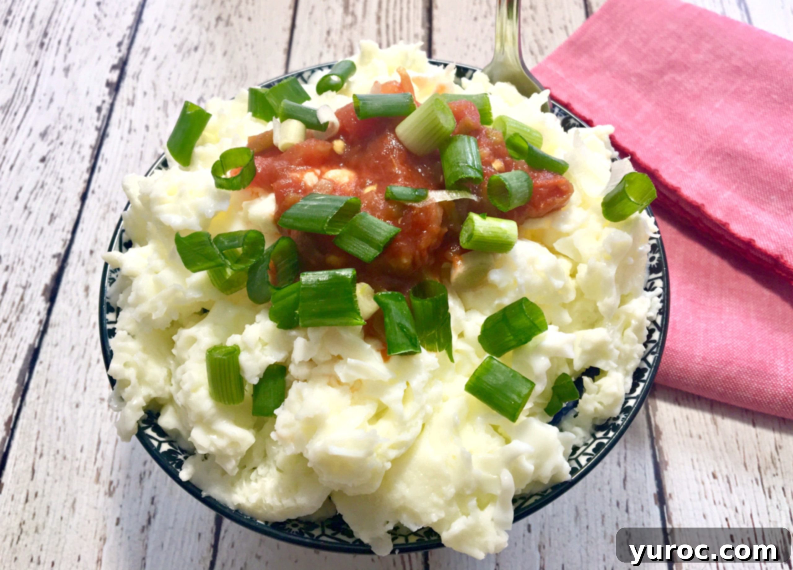 A healthy serving of microwaved egg whites with fresh salsa and green onion, presented in a white bowl with a red napkin beside it.