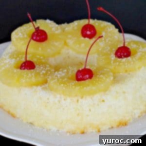 Weight Watchers Pineapple Pina Colada Cake on a white plate with tropical garnish