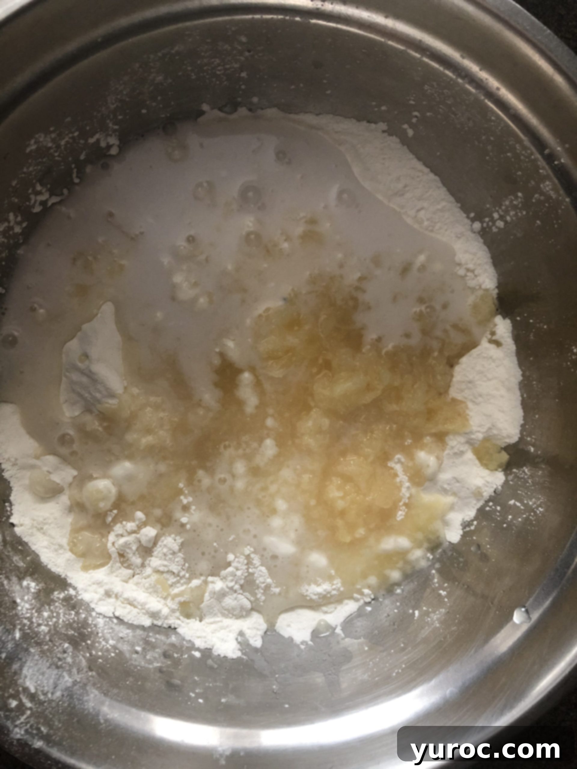 Dry angel food cake mix, crushed pineapple, light coconut milk, and coconut extract in a mixing bowl
