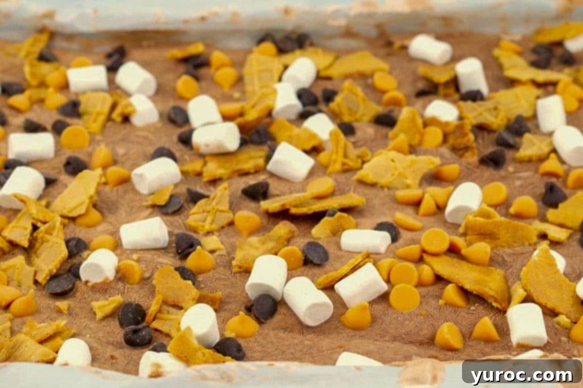 Rocky Road Frozen Greek Yogurt Bark on a parchment-lined sheet pan, featuring chocolate, marshmallows, and nuts