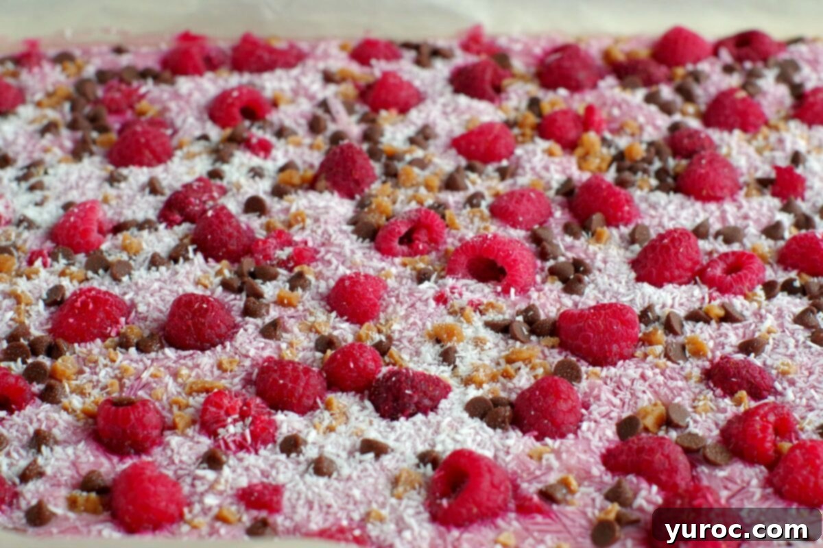 Frozen yogurt bark, still whole, resting on a parchment-lined cookie sheet after freezing