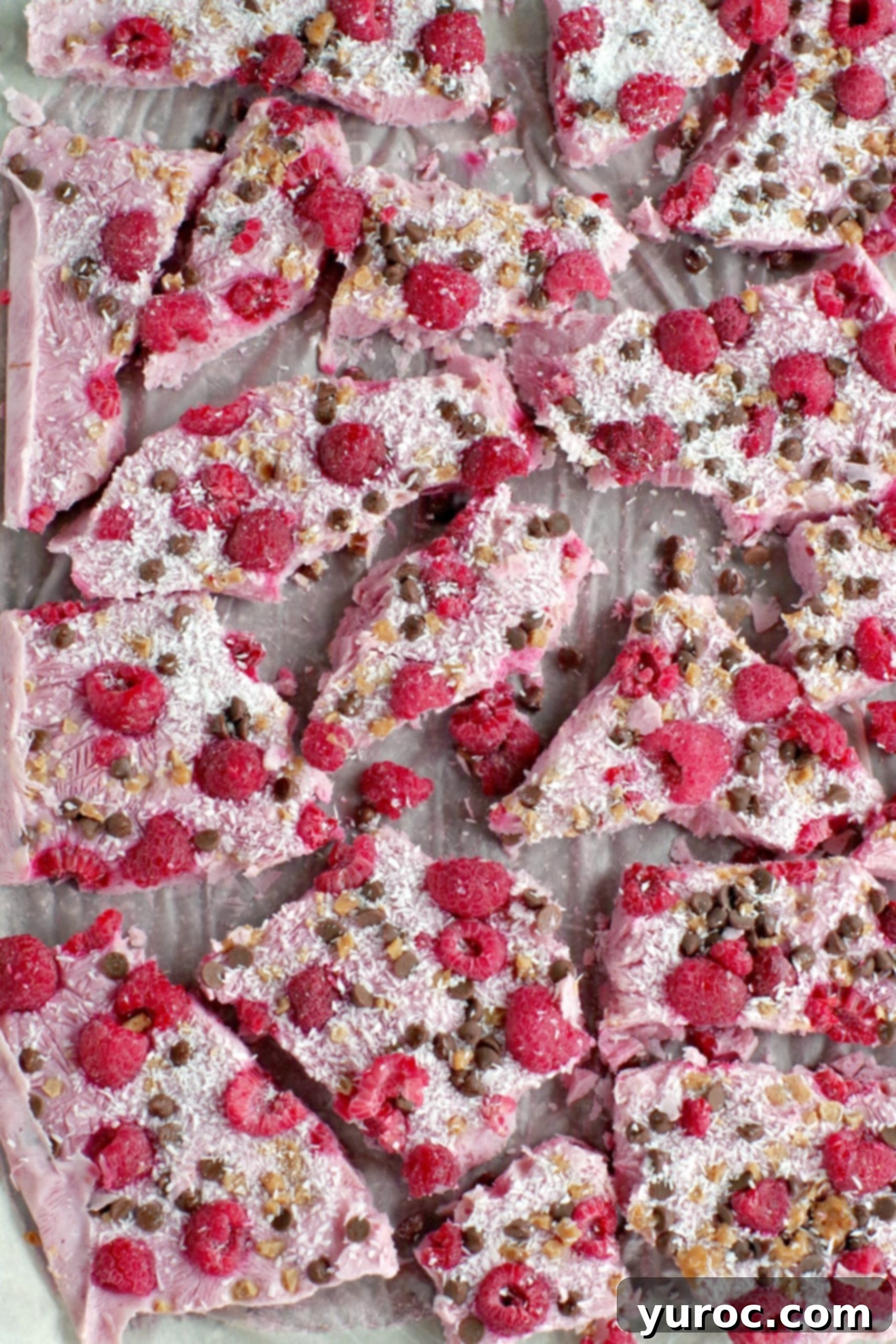 Large tray of raspberry frozen yogurt bark, broken into many pieces, ready to be stored or served