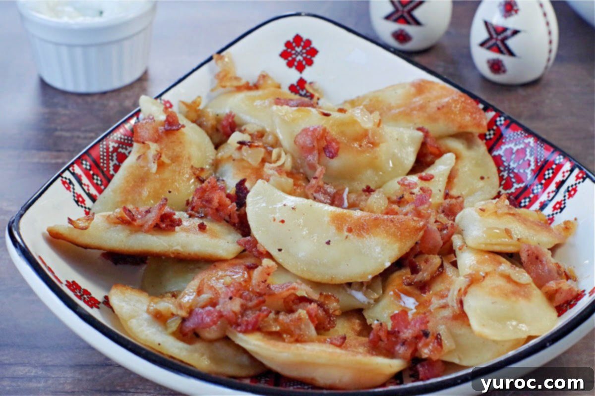 Ukrainian perogies covered in bacon and onion in a ukrainian print dish