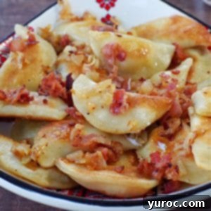 Ukrainian perogies covered in bacon and onion in a ukrainian print dish