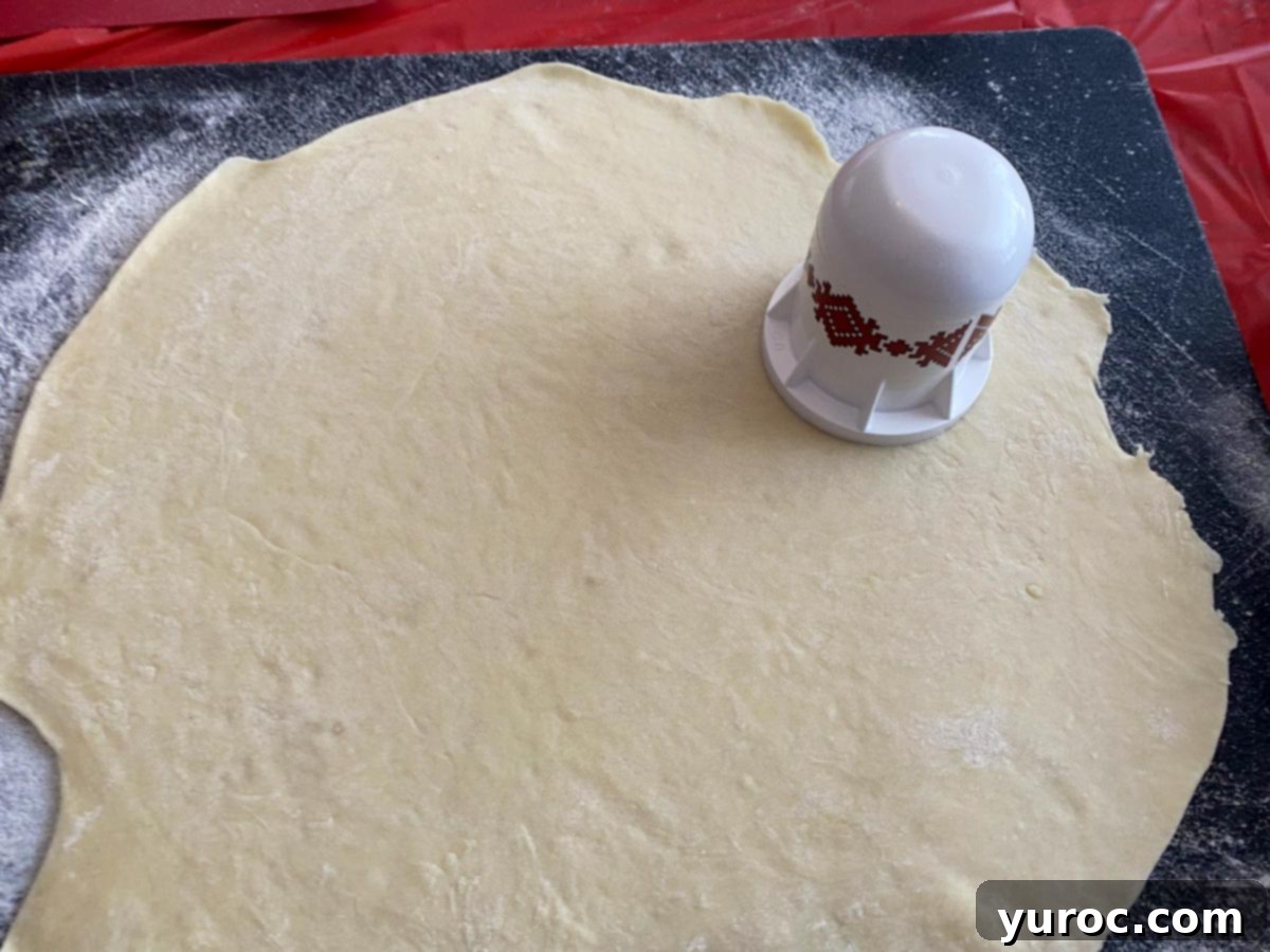 perogy dough rolled out on cutting board with perogy cutter