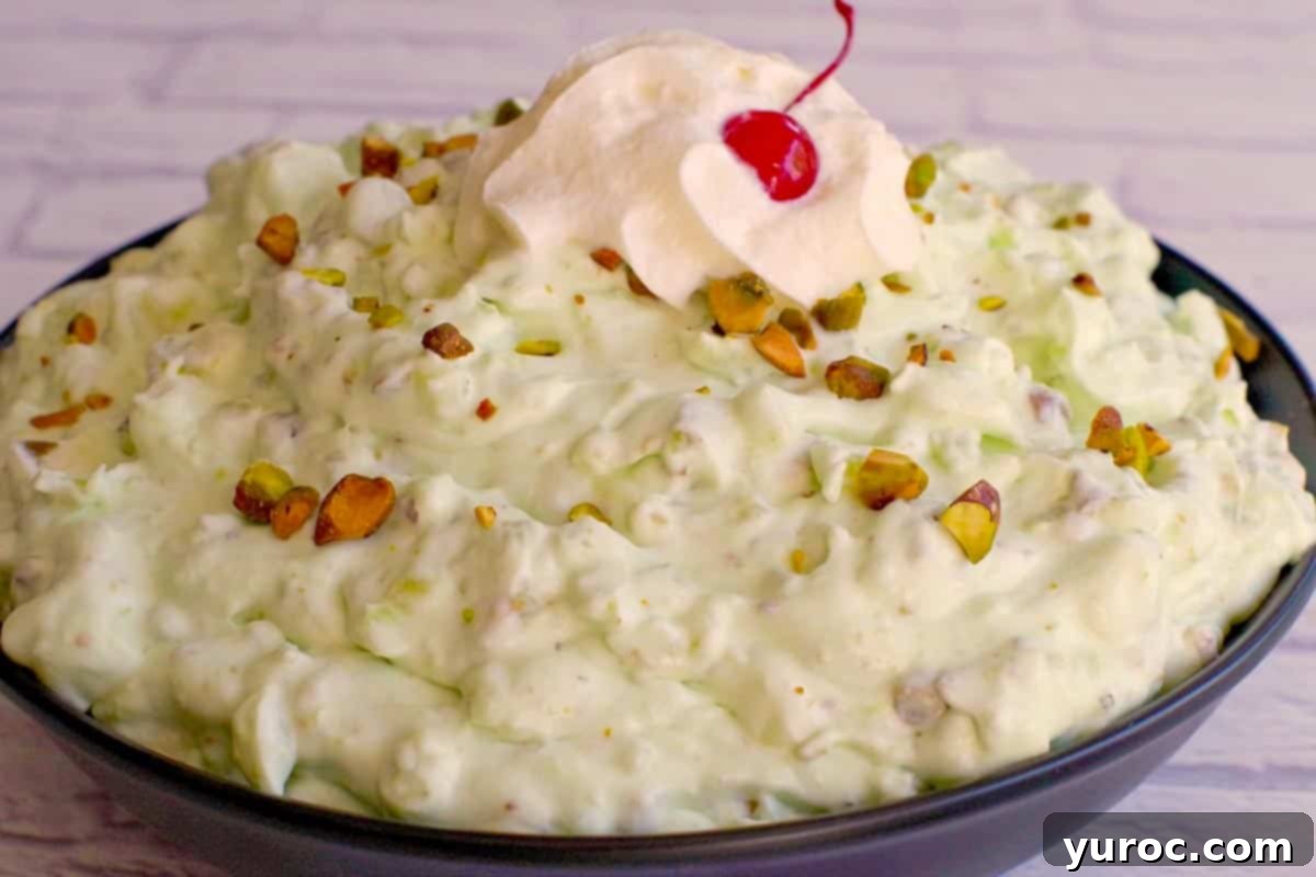 Creamy Pistachio Fluff 4 A large black serving bowl filled with a generous amount of prepared Pistachio Fluff dessert, ready to be chilled or served.