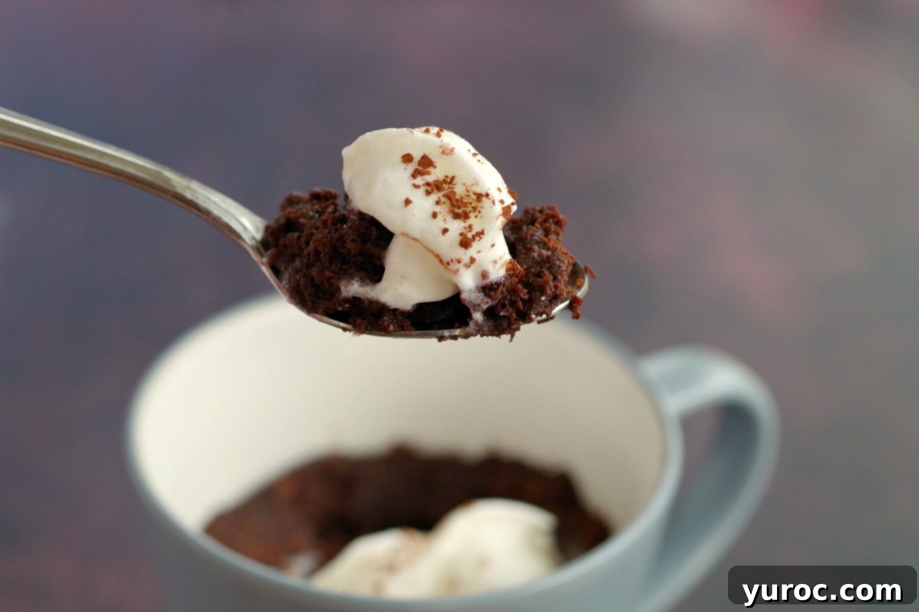 Instant Guilt-Free Chocolate Banana Mug Cake 1 A healthy chocolate mug cake being held up on a spoon, showing its rich texture.