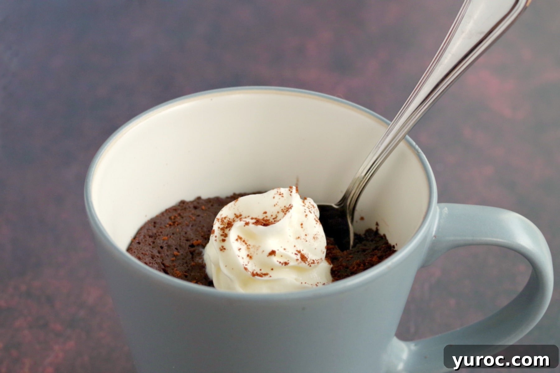 Instant Guilt-Free Chocolate Banana Mug Cake 2 A spoon scooping a bite from a fluffy microwave chocolate banana mug cake.