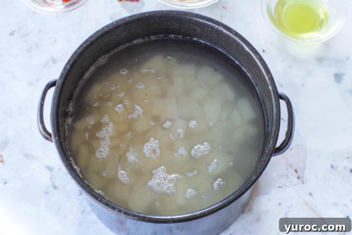 Peeled and diced potatoes in a large pot, covered in water.