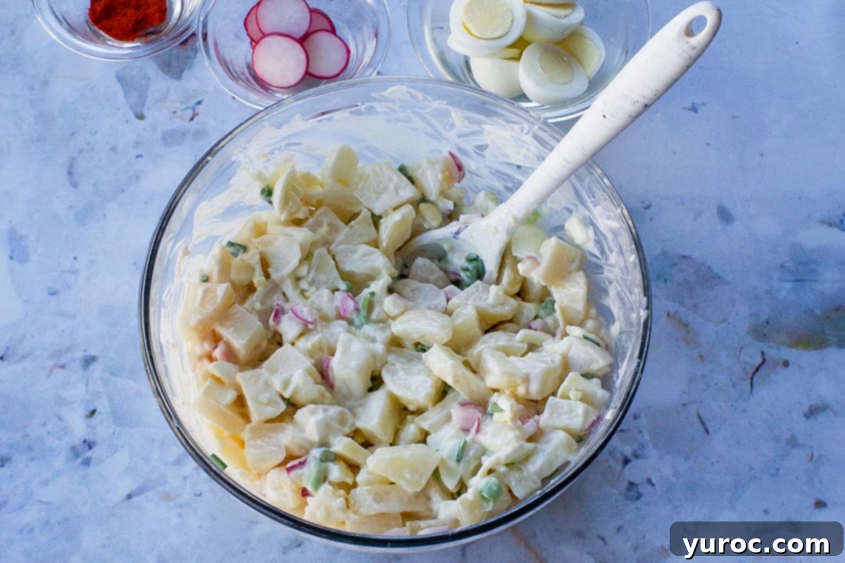 Potato salad ingredients mixed together in a bowl.