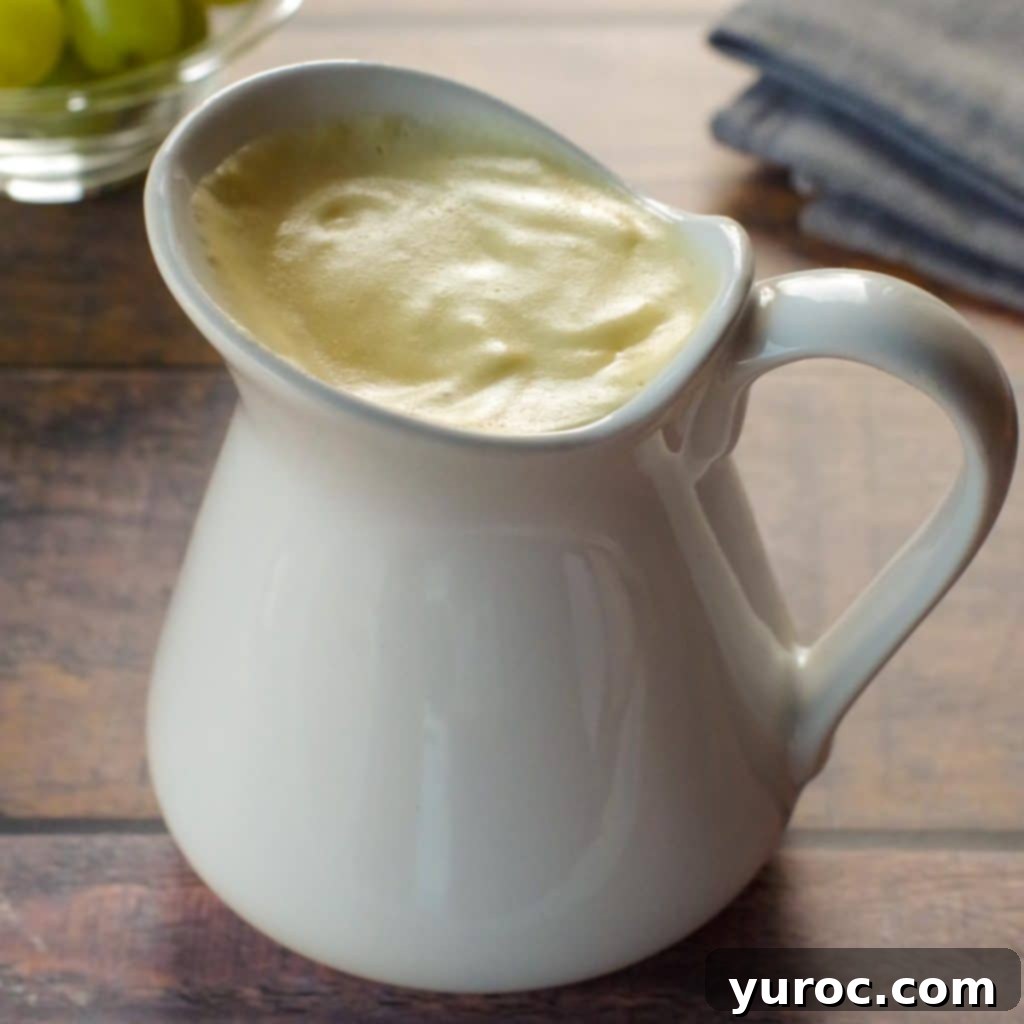 Lightened Up Old Fashioned Banana Cream Pie 4 Healthy Hollandaise sauce beautifully presented in a large white creamer, with a bowl of fresh green grapes and a grey linen napkin in the background.