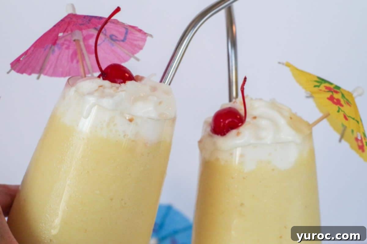 Two healthy Pina Colada glasses clinking together, celebrating the refreshing drinks.