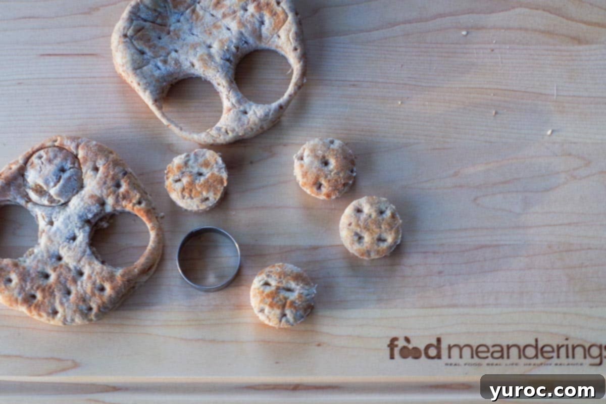 Mini buns cut out of thin buns with mini round cookie cutter on cutting board.