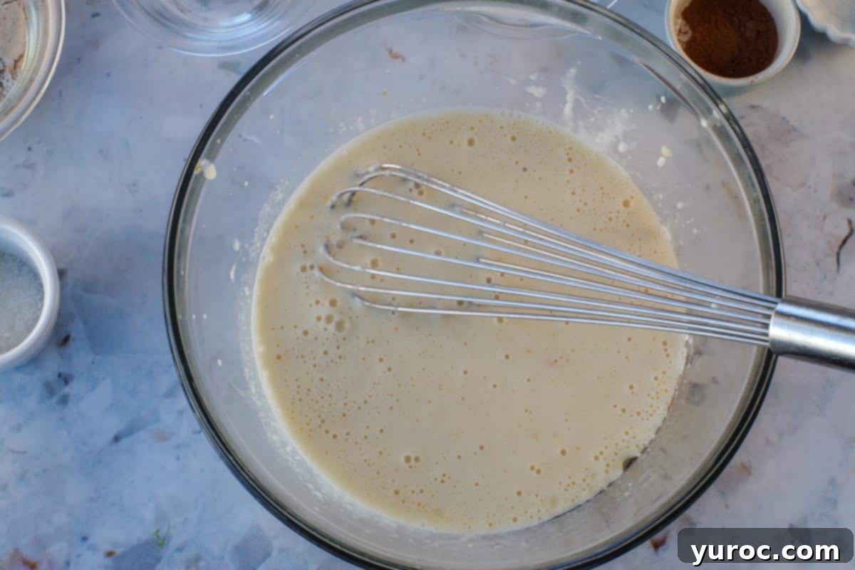 Baking soda added to large glass bowl with whisk.