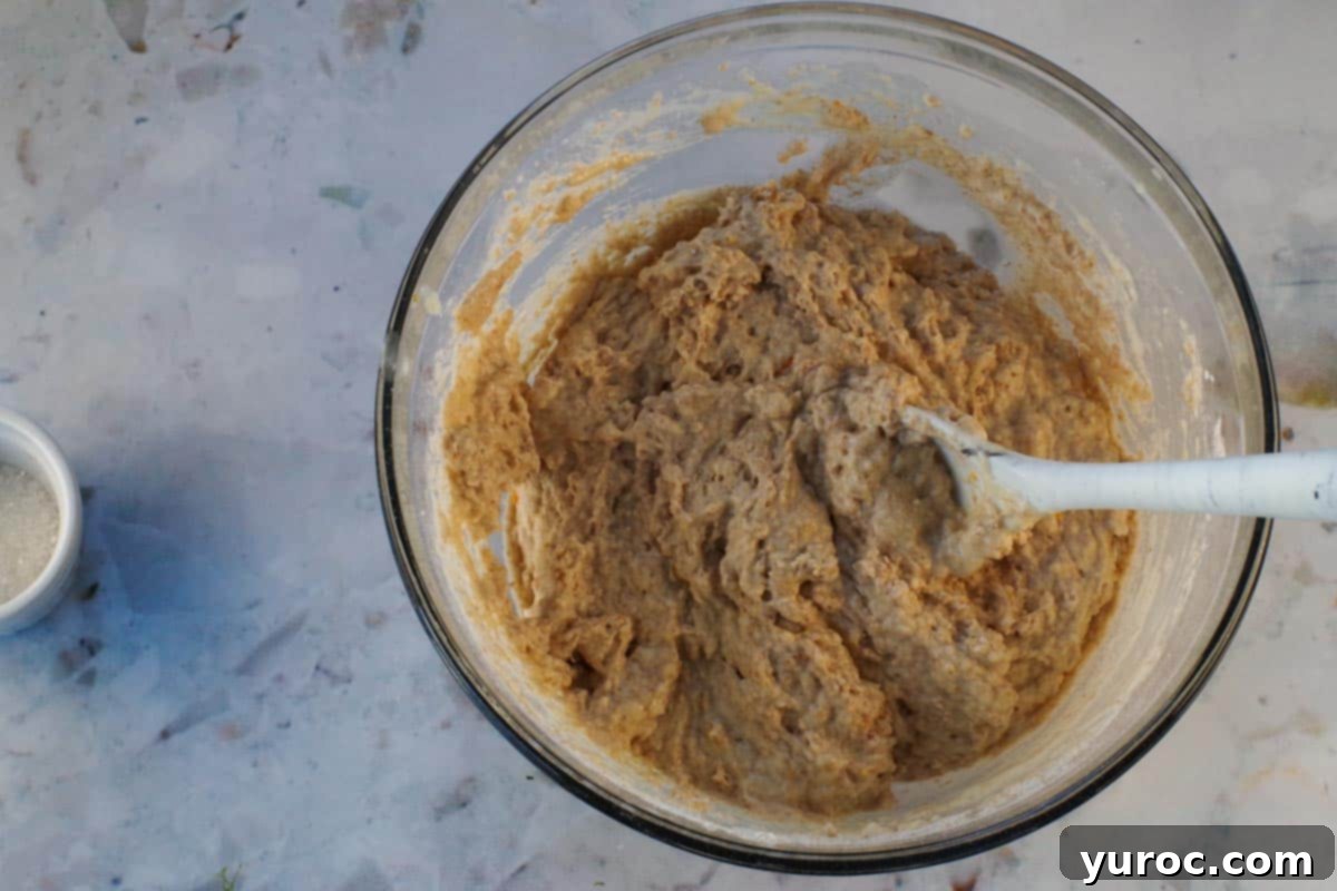 Wet and dry ingredients mixed together until just combined in large glass bowl with marble silicone spoon.