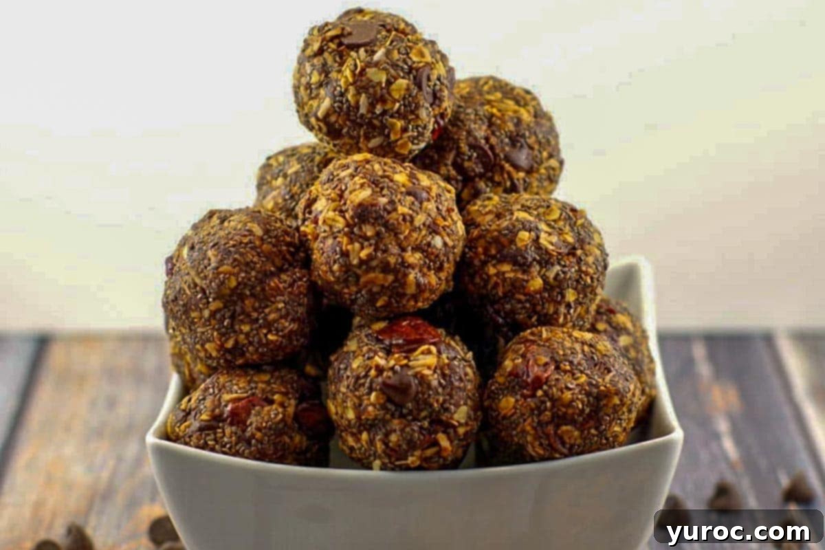 Cherry Chocolate Power Bites 2 Close-up of three chocolate cherry energy balls on a rustic wooden surface, highlighting their rich color and texture.