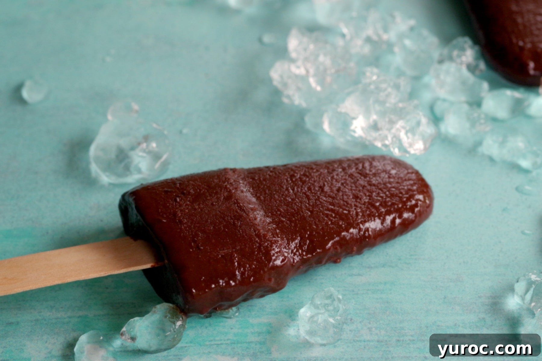 Decadent Yet Light Chocolate Banana Pops 3 Chocolate banana popsicle with ice around it