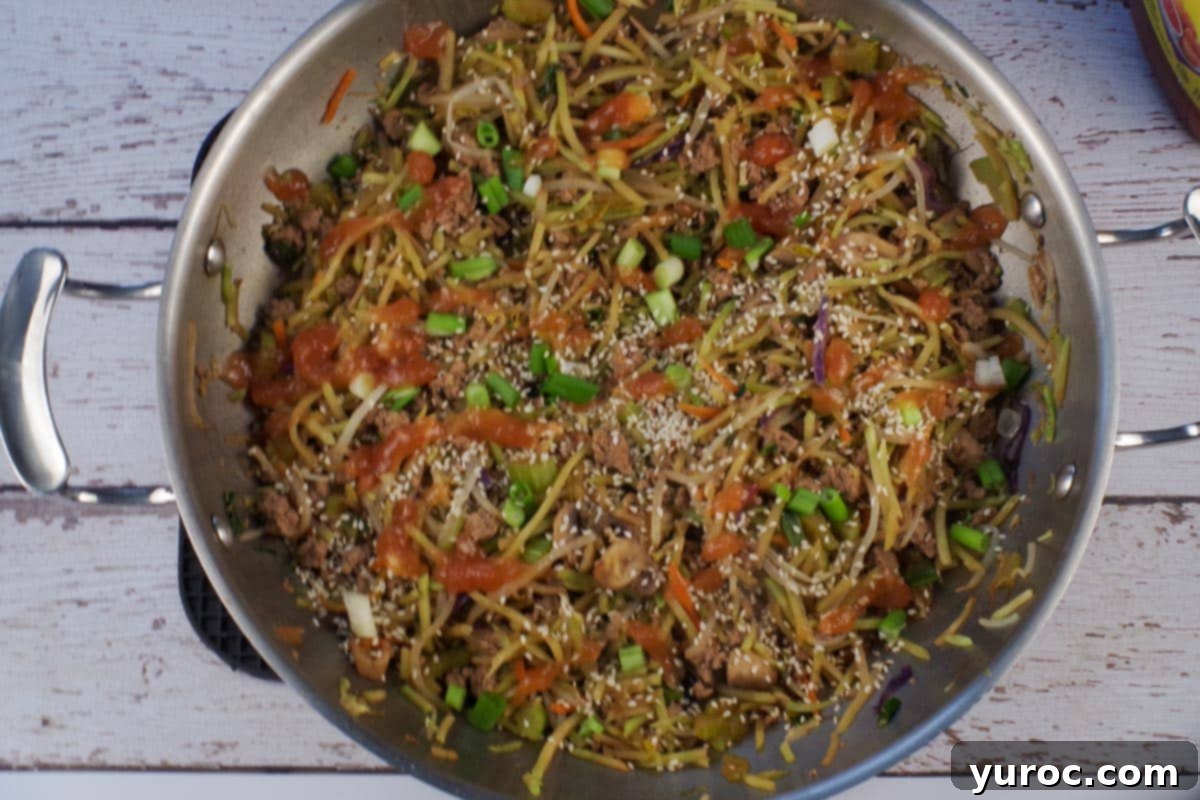 Cooked and garnished ww egg roll in a bowl in wok.
