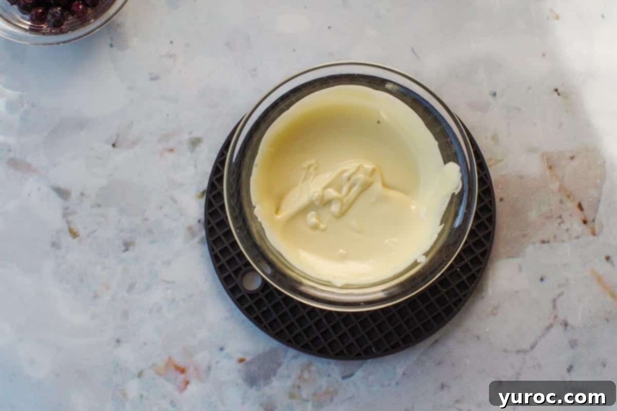 No-Bake Saskatoon Berry Cheesecake Jars 6 Melted white chocolate in a small glass bowl.