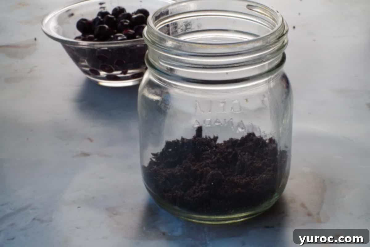 No-Bake Saskatoon Berry Cheesecake Jars 8 Chocolate crust mixture added to bottom of mason jar.