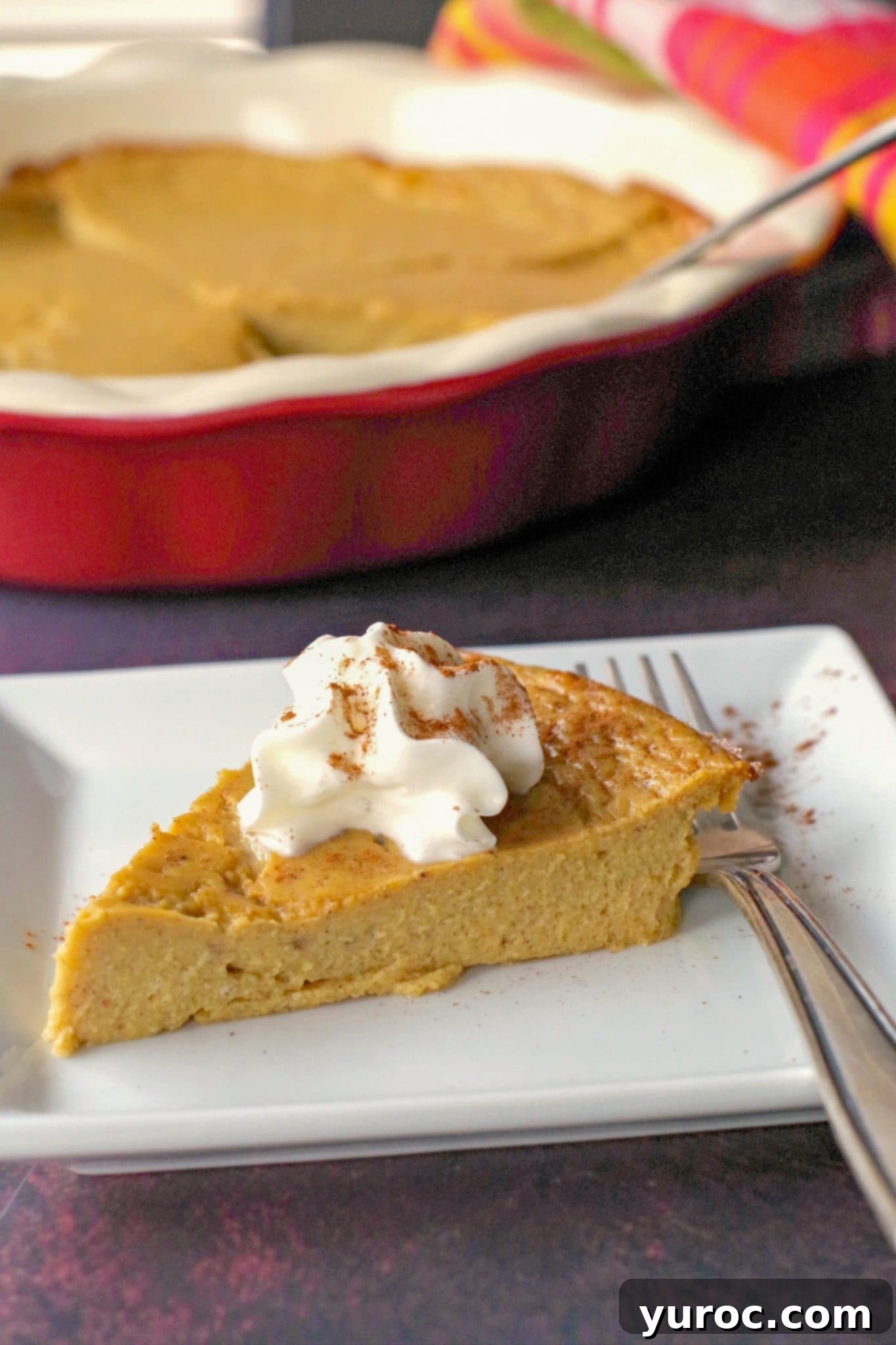 WW no crust pumpkin pie on a white plate with fork, whole pie in background, showcasing a delicious and healthy dessert option