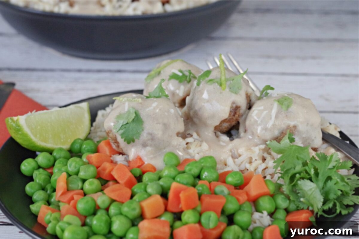 turkey pesto meatballs on rice with mixed vegetables, on a black plate