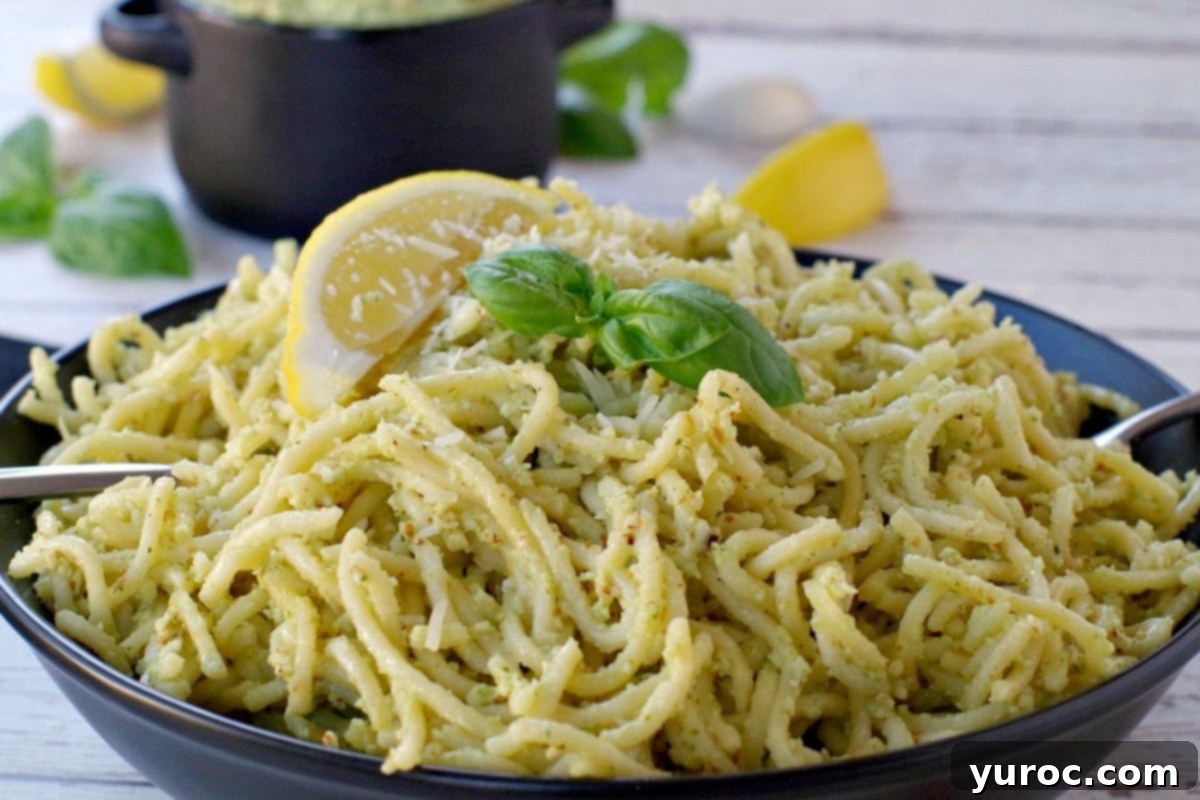 pesto on spaghetti noodles with more pesto (in black container in background)