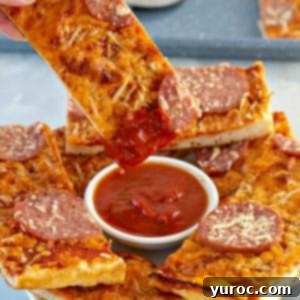 Pizza dipper being dipped into pizza sauce with pieces of pieces around it on white plate. White ranch dip on plate as well.