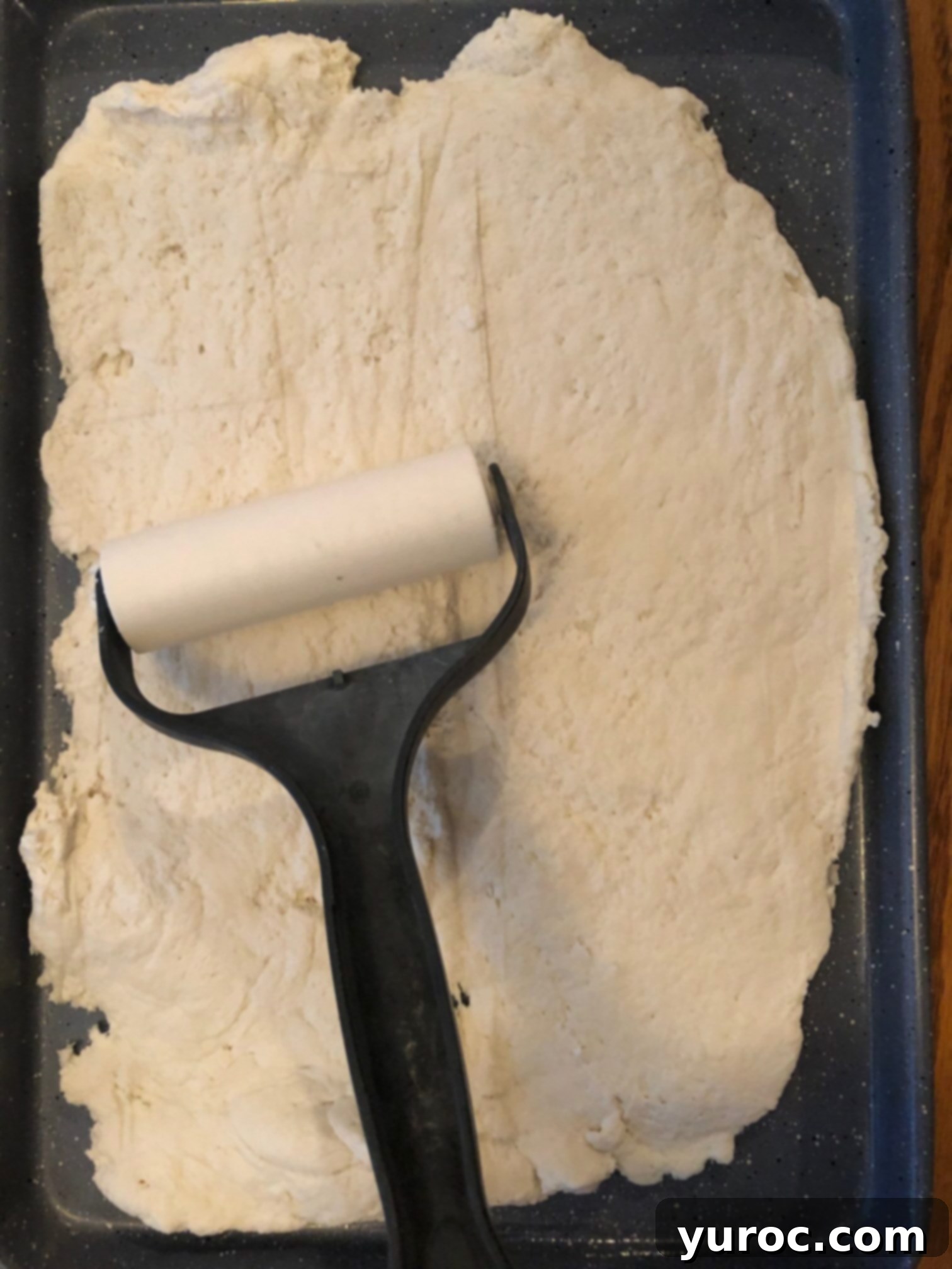 dough being rolled out onto cookie sheet