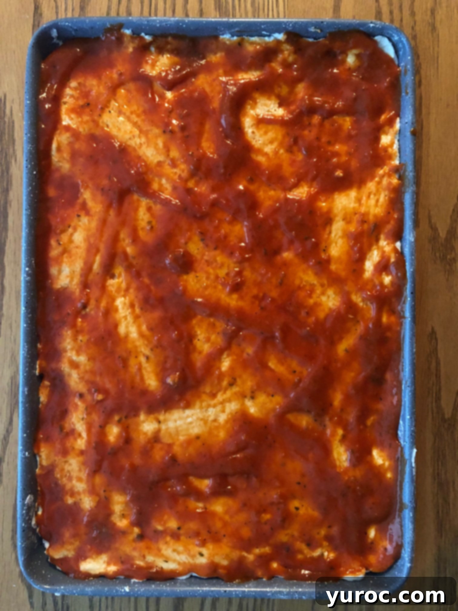 Pizza sauce spread evenly on 2 ingredient dough