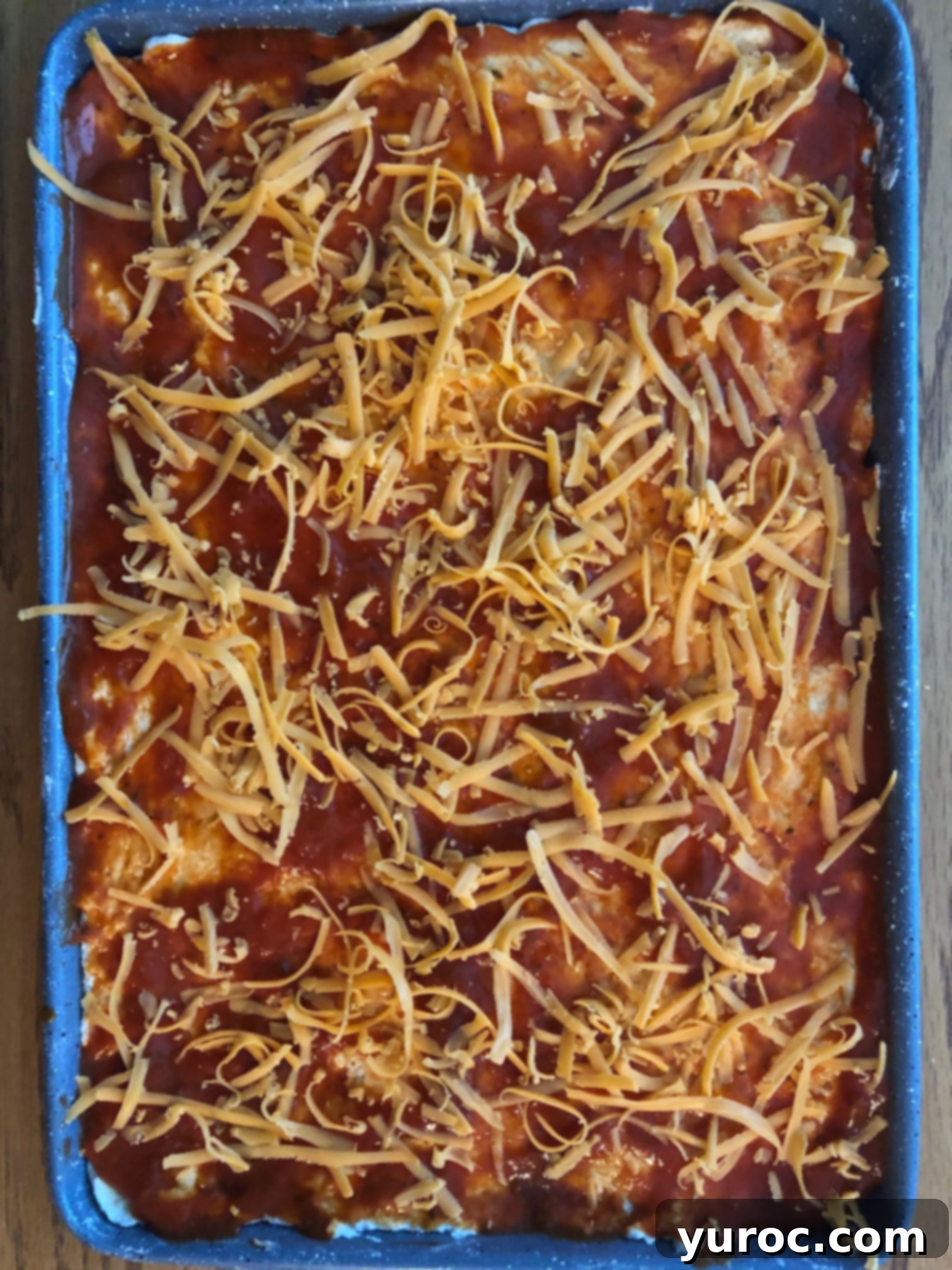 cheddar cheese on top of pizza sauce