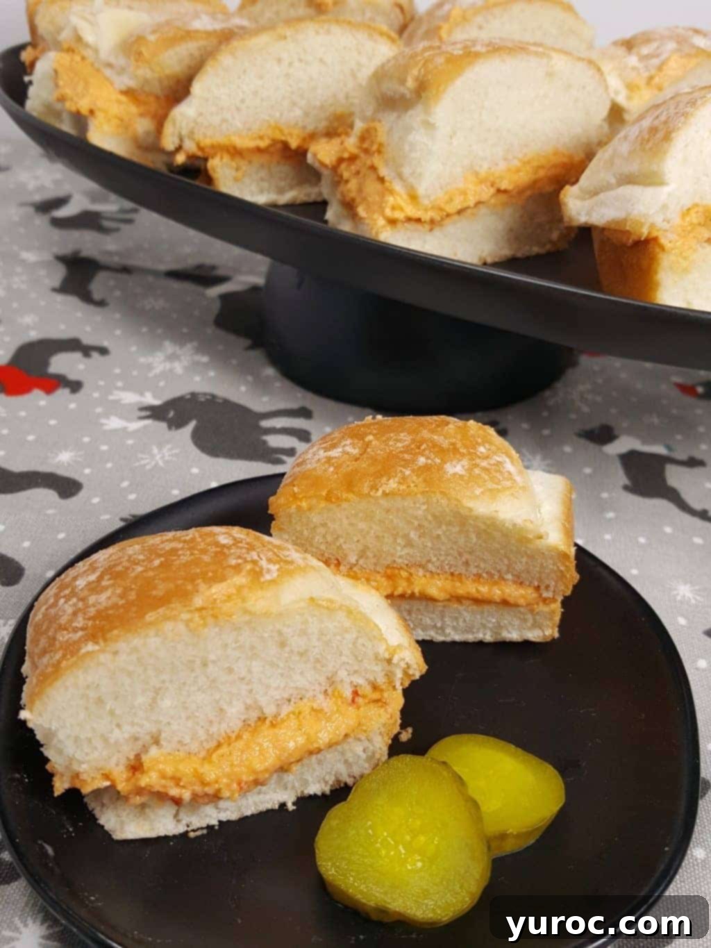 15 No-Prep Healthy School Lunches for Teens 10 cuban deviled ham sandwiches on black plate with more sandwiches in background, filled with ham, cream cheese and roasted red peppers