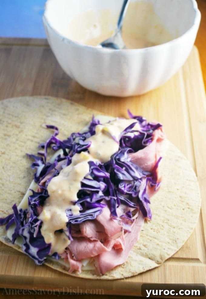 15 No-Prep Healthy School Lunches for Teens 15 lighter reuben wrap - ingredients on tortilla, with deli roast beef, baby Swiss cheese, red cabbage, and homemade thousand island dressing