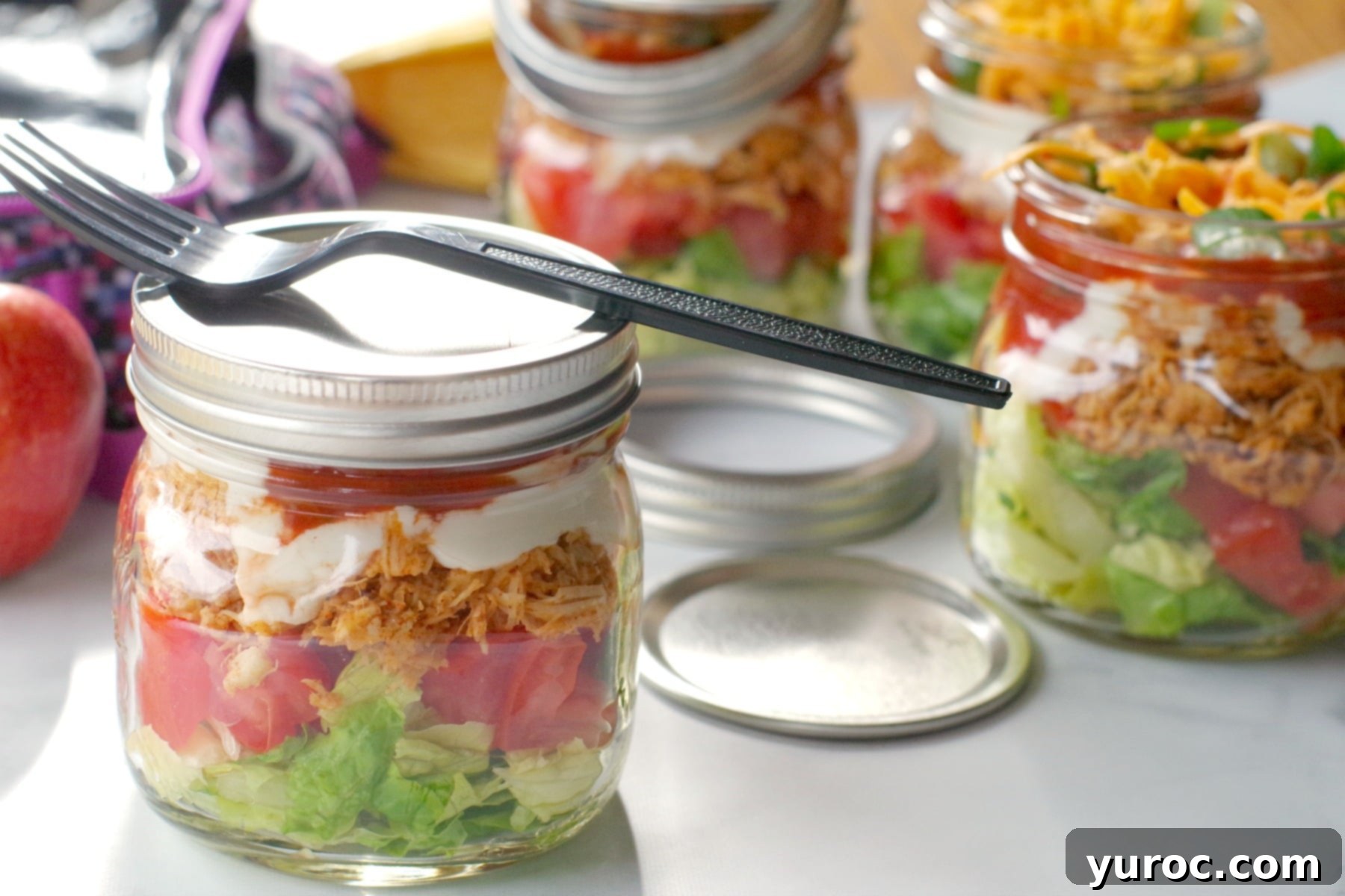 chicken taco salad in a mason jar with lid on and more jars in background