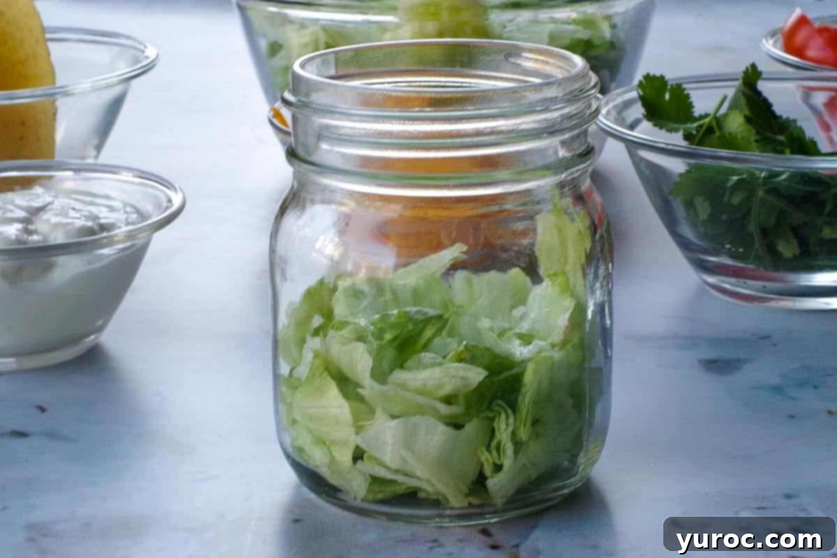 Lettuce placed in the bottom of an 8 oz jar.