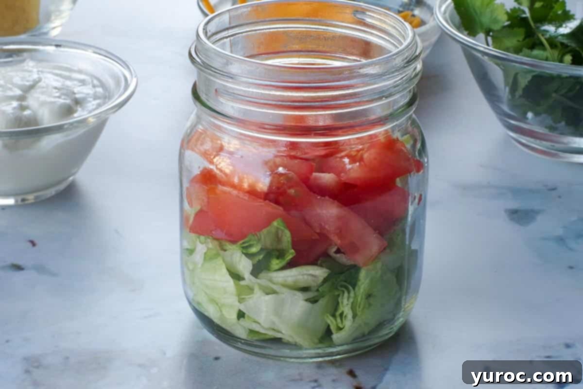 Tomatoes added on top of lettuce in 8 oz jar.