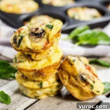 3 muffin tin omelettes stacked on top of each other, with one leaning against the tower of muffins