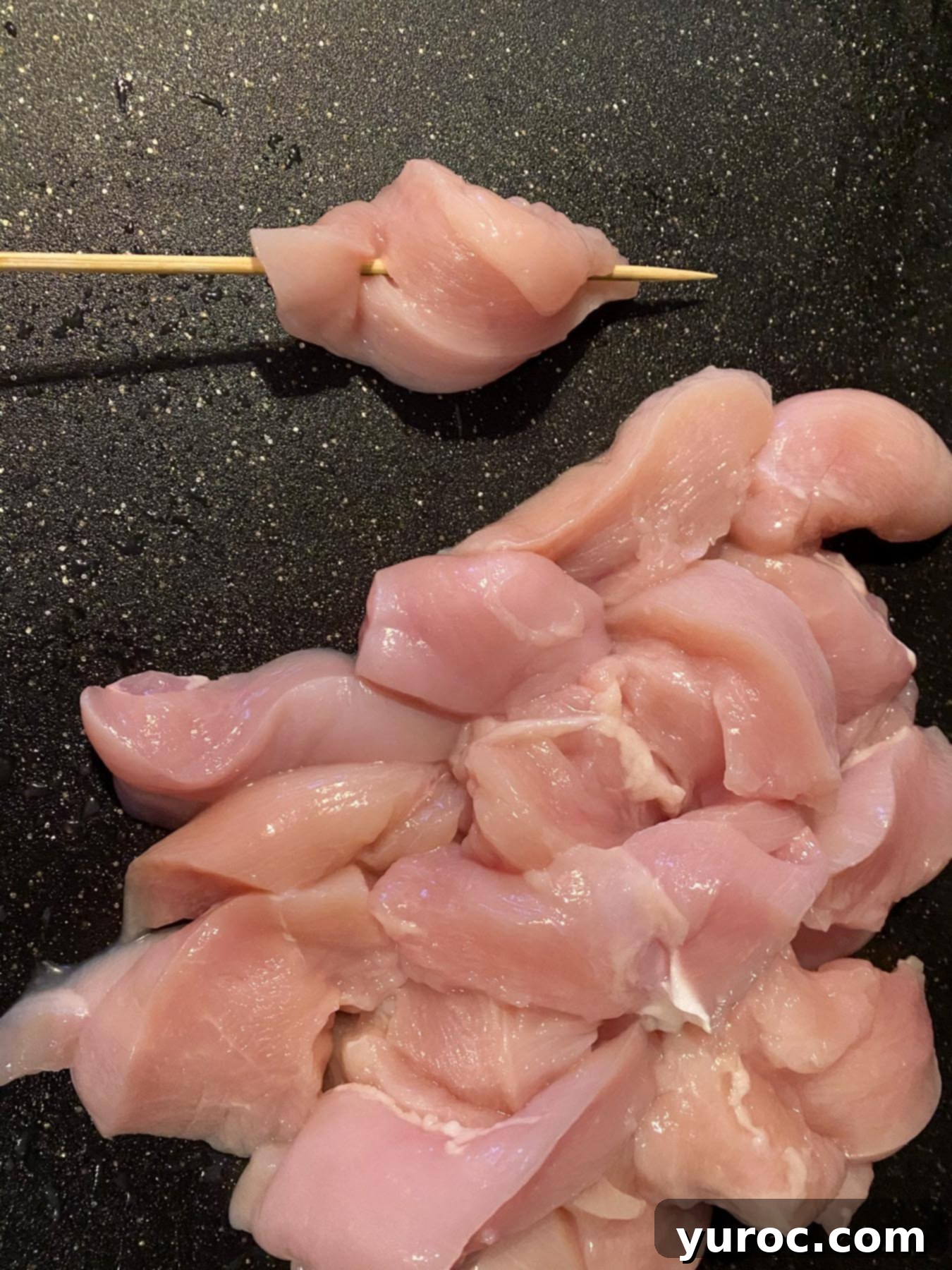 chicken strips being added to skewers