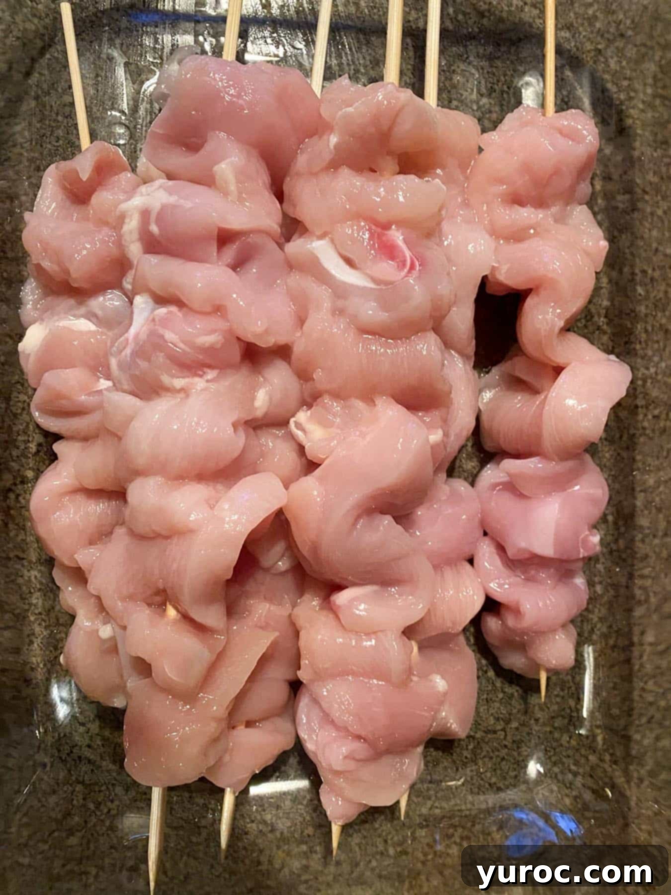 all chicken pieces on skewer in a container