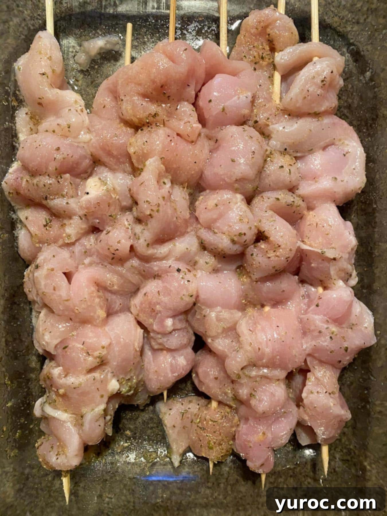 marinated chicken skewers in container