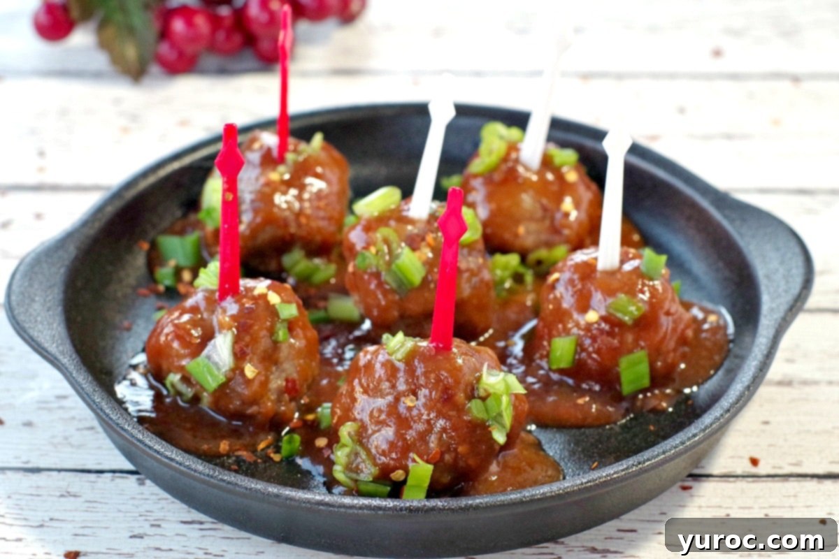 6 slow cooker turkey meatballs with red and white skewers on a black, round serving platter