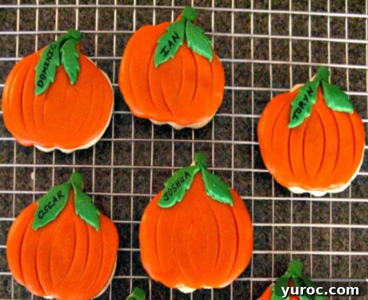 fondant covered orange Halloween pumpkin cookies on wire cooling rack