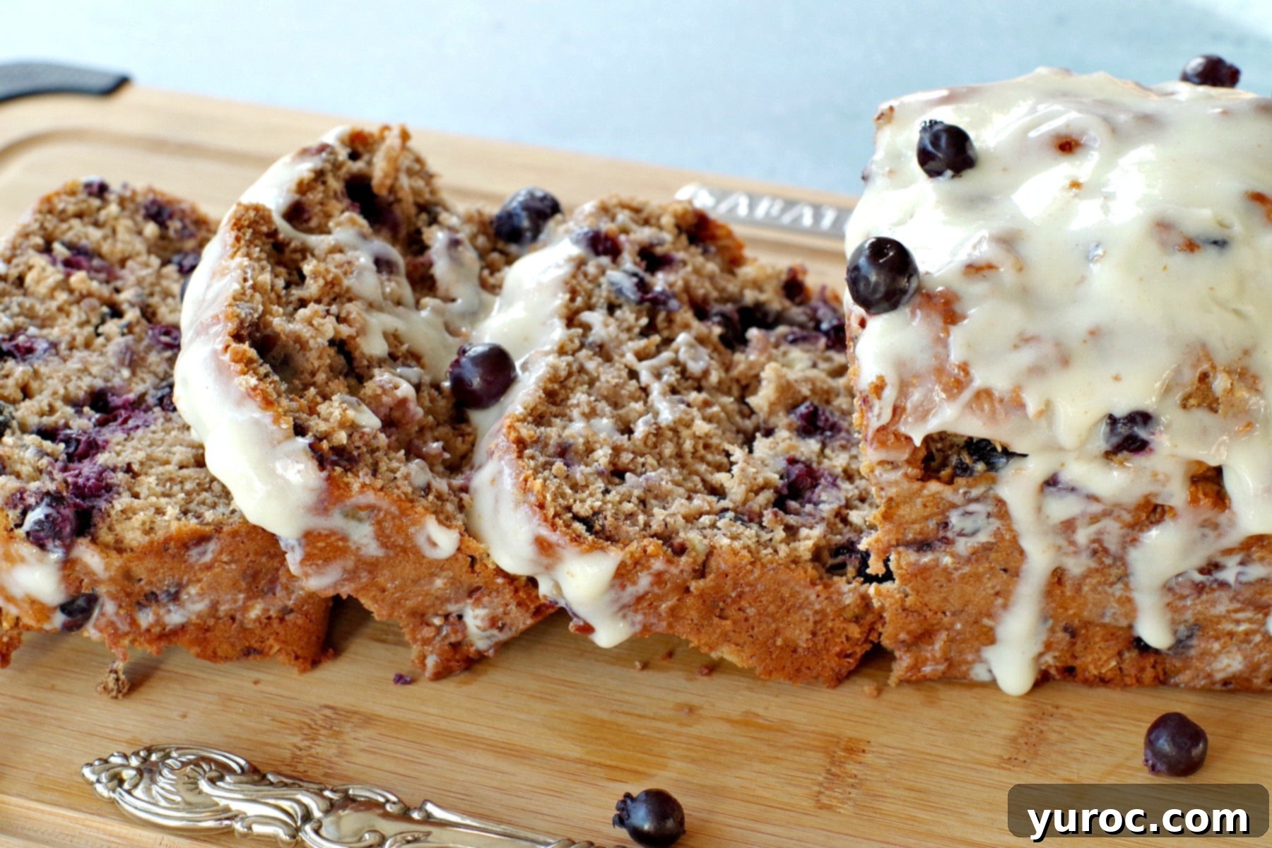 Sliced Saskatoon berry loaf on cutting board with a rich brown butter glaze