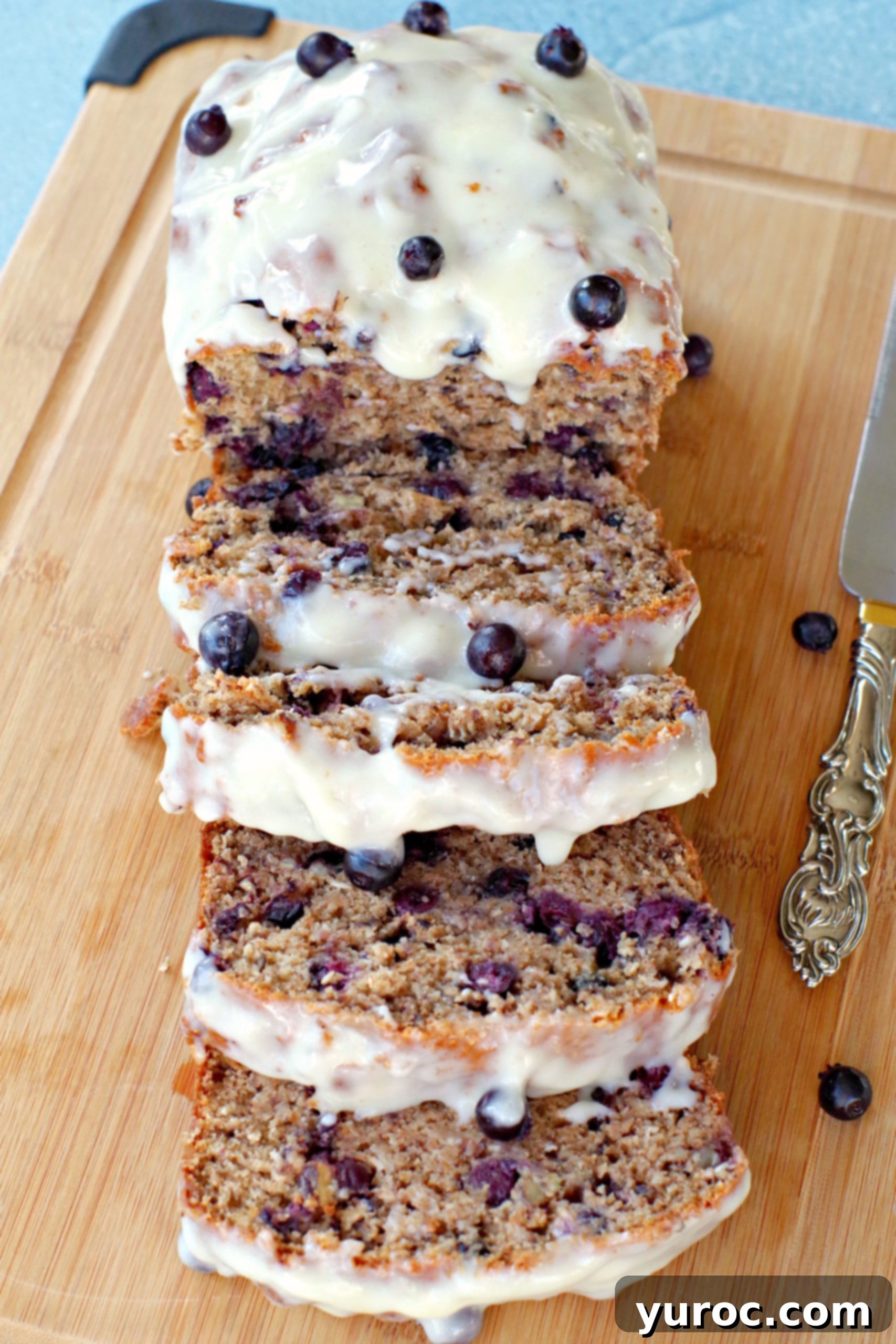Saskatoon berry loaf sliced on a cutting board, showing the juicy berries and tender crumb